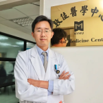 楊智傑主任於研究中心門前與中心招牌合影