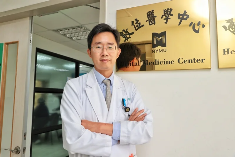 楊智傑主任於研究中心門前與中心招牌合影